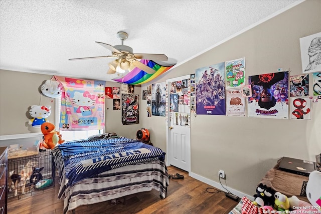 bedroom featuring ceiling fan, a textured ceiling, ornamental molding, and wood-type flooring