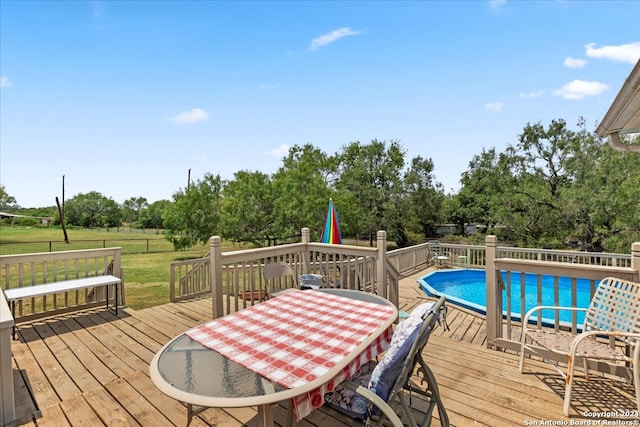 view of pool featuring a wooden deck and a lawn