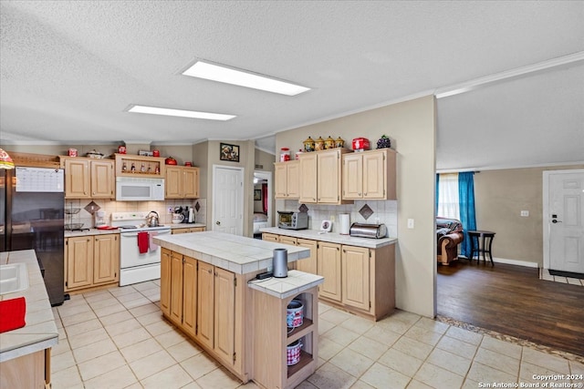 kitchen with light brown cabinetry, white appliances, lofted ceiling, and light hardwood / wood-style floors