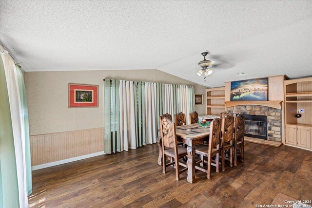 dining area featuring ceiling fan, vaulted ceiling, dark wood-type flooring, and a textured ceiling