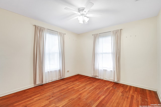 unfurnished room featuring ceiling fan, hardwood / wood-style flooring, and plenty of natural light