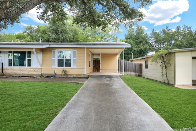 ranch-style house featuring a front yard and a carport