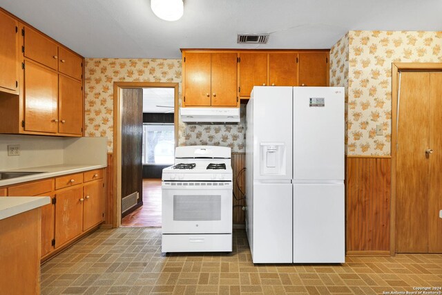 kitchen with white appliances and light hardwood / wood-style floors