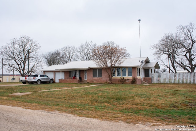 single story home with a front yard and a garage