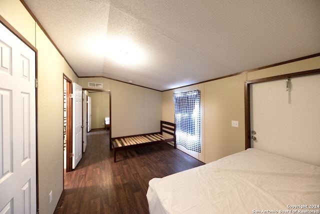 bedroom featuring hardwood / wood-style flooring, a textured ceiling, and vaulted ceiling