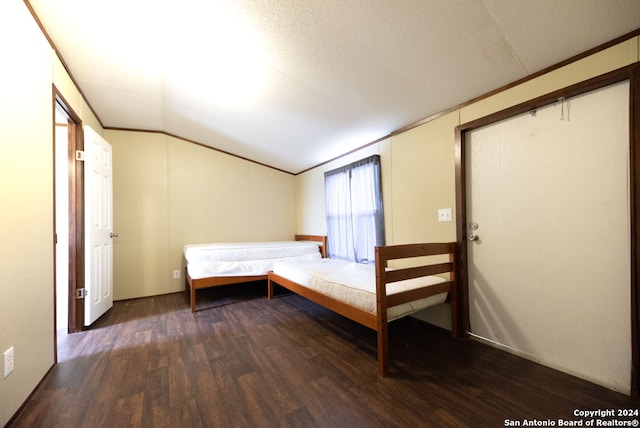 unfurnished bedroom featuring a textured ceiling, wood-type flooring, and lofted ceiling