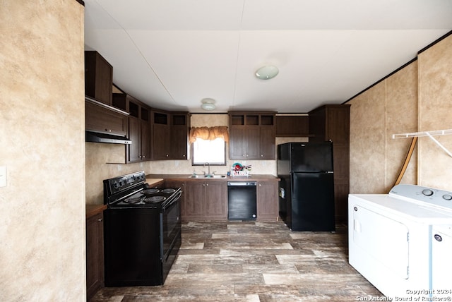 kitchen featuring washer and clothes dryer, wood-type flooring, sink, black appliances, and dark brown cabinetry