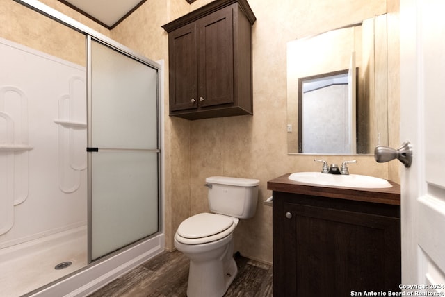 bathroom featuring walk in shower, toilet, vanity, and wood-type flooring