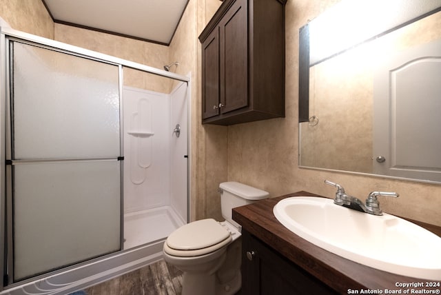 bathroom with an enclosed shower, wood-type flooring, vanity, and toilet