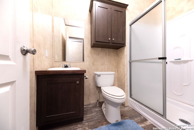 bathroom with walk in shower, wood-type flooring, vanity, and toilet