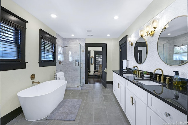 223 E Craig Pl, San Antonio, TX 78212 - full bathroom with double vanity, a shower stall, a freestanding bath, tile patterned flooring, and recessed lighting
