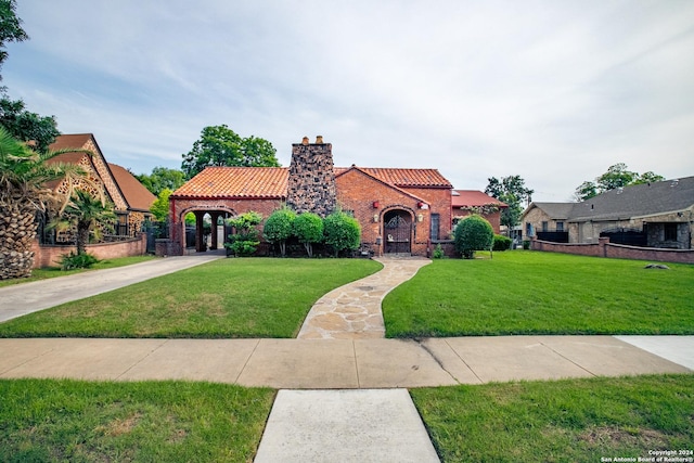 mediterranean / spanish-style house with a front yard