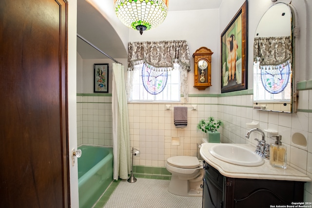 full bathroom featuring toilet, tile walls, tile patterned floors, shower / bath combo with shower curtain, and vanity