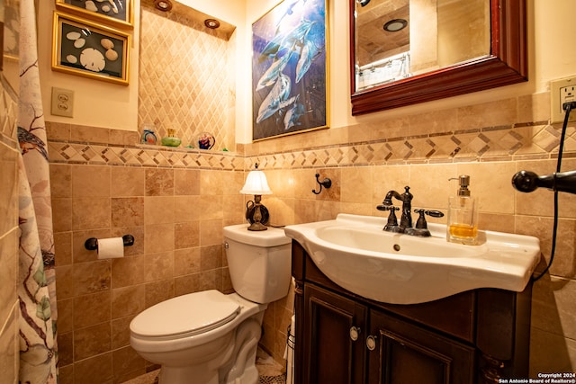 bathroom featuring tile walls, toilet, and vanity