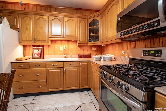 kitchen featuring light tile patterned floors, stainless steel appliances, and sink