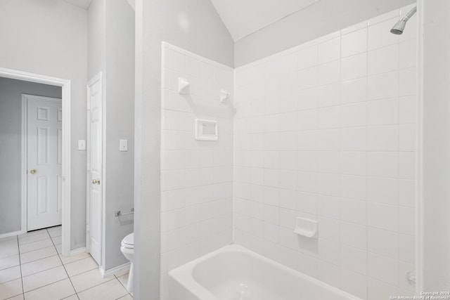 bathroom featuring tiled shower / bath, tile patterned floors, toilet, and vaulted ceiling