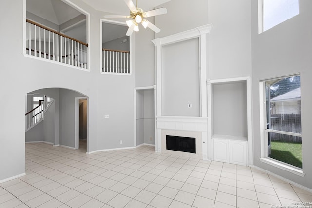 unfurnished living room with light tile patterned flooring, plenty of natural light, and ceiling fan