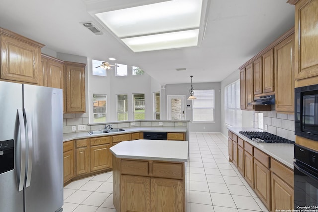 kitchen featuring light tile patterned flooring, sink, a center island, kitchen peninsula, and black appliances