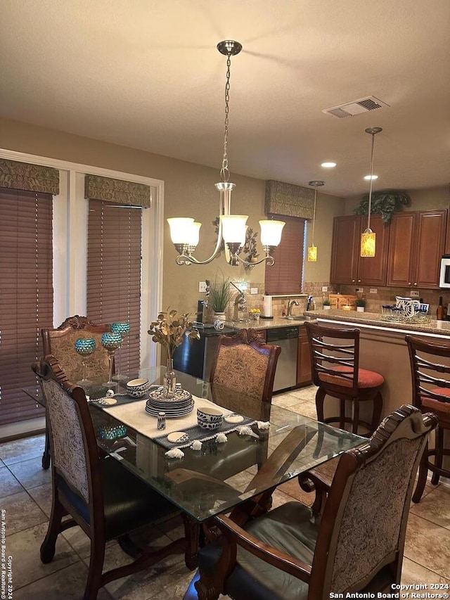 tiled dining space featuring an inviting chandelier and sink