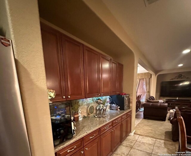 kitchen featuring light stone counters, recessed lighting, open floor plan, backsplash, and light tile patterned floors