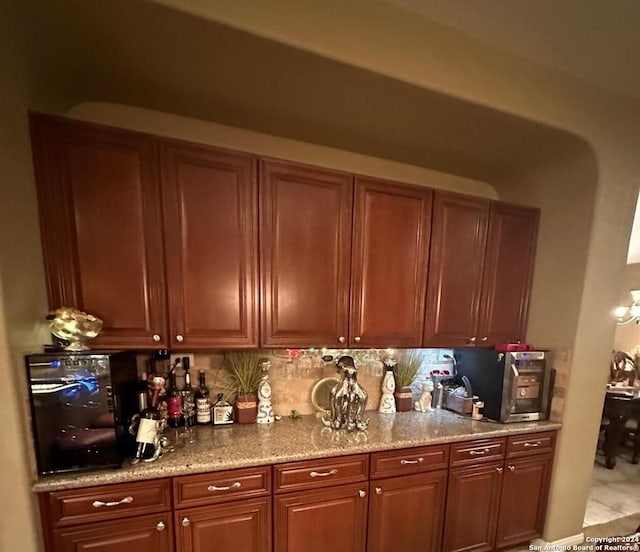 kitchen featuring light stone countertops, decorative backsplash, and brown cabinetry