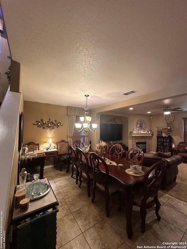 tiled dining area featuring a notable chandelier and a textured ceiling