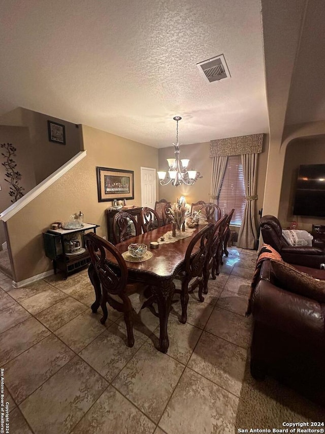dining room with visible vents, a notable chandelier, and a textured ceiling