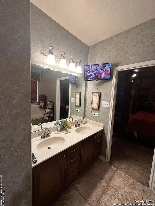 bathroom featuring double vanity, a sink, and tile patterned floors