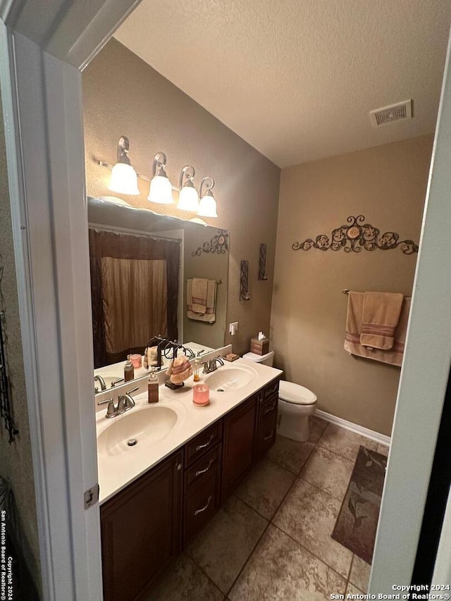 full bathroom with toilet, a sink, visible vents, and a textured ceiling