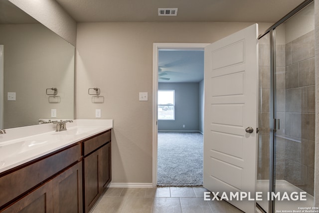 bathroom with walk in shower, vanity, and tile patterned flooring