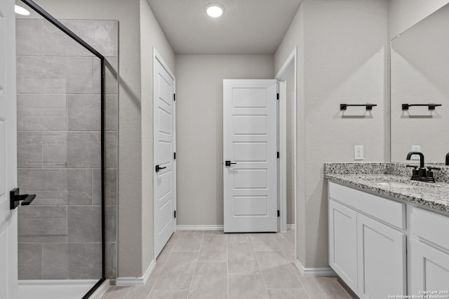 bathroom with an enclosed shower, vanity, and tile patterned floors