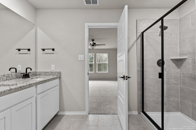 bathroom featuring walk in shower, ceiling fan, and vanity