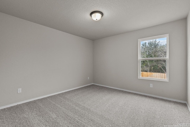 carpeted empty room featuring a textured ceiling