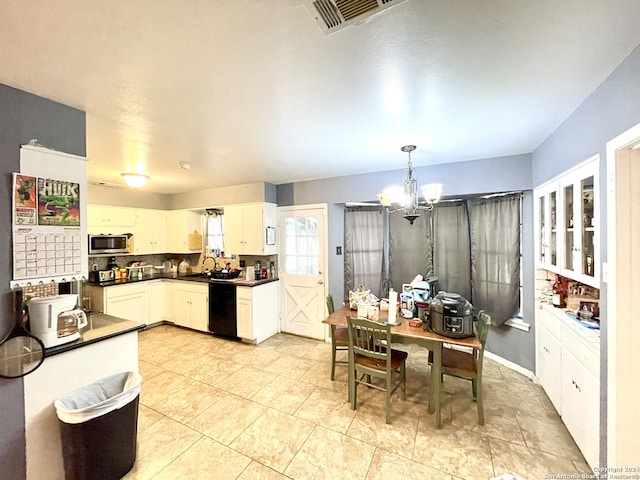 kitchen featuring white cabinets, hanging light fixtures, tasteful backsplash, an inviting chandelier, and black dishwasher