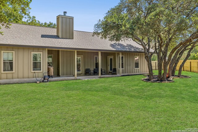 rear view of house featuring a yard