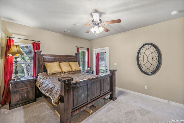 bedroom featuring ceiling fan, a textured ceiling, and light carpet