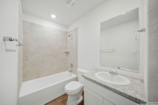 full bathroom with vanity, tiled shower / bath, and toilet