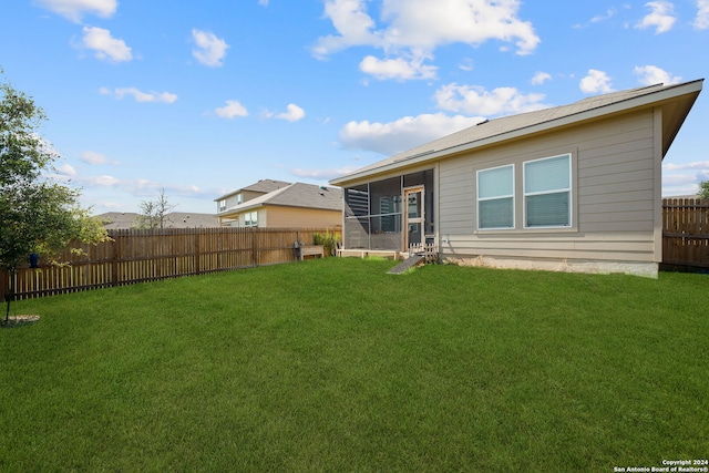 back of property featuring a lawn and a sunroom