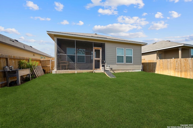 back of property with a sunroom and a yard