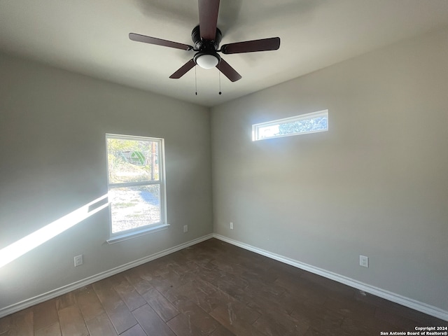 empty room featuring dark hardwood / wood-style flooring, a wealth of natural light, and ceiling fan