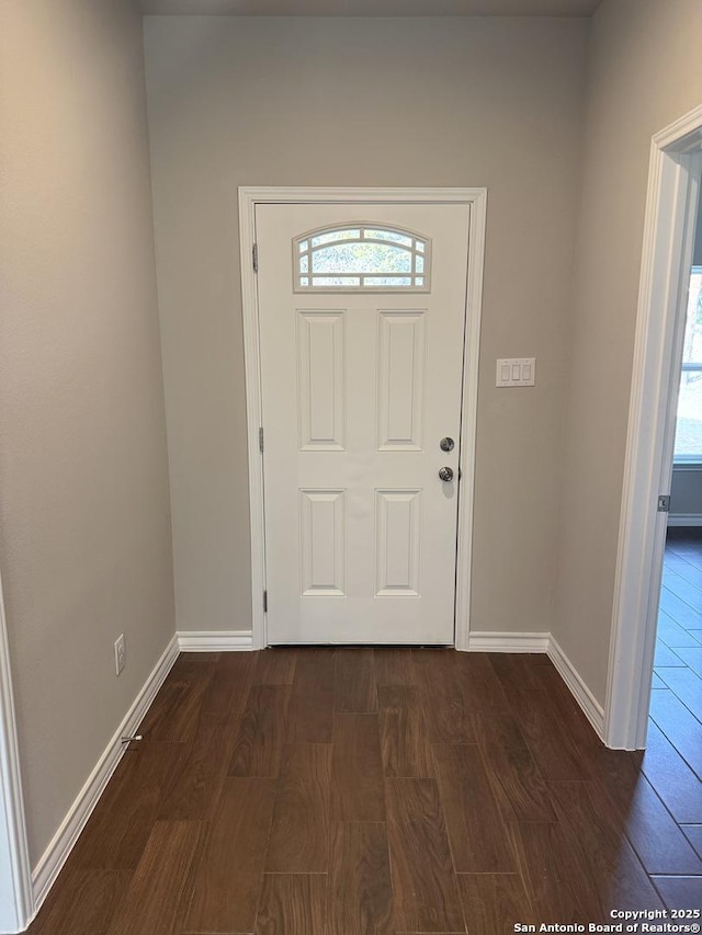 foyer entrance featuring dark wood-type flooring and baseboards