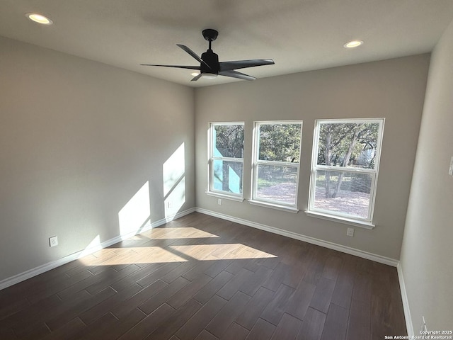 empty room with a ceiling fan, recessed lighting, dark wood-style flooring, and baseboards