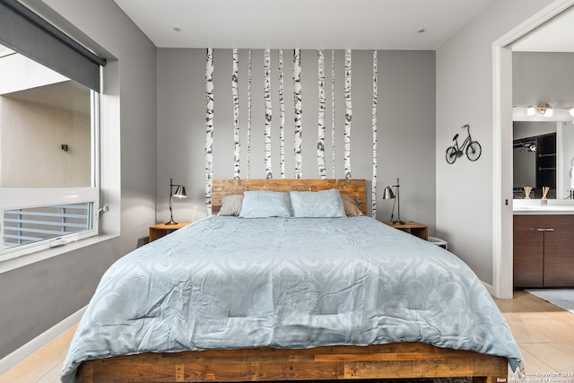 bedroom featuring light tile patterned flooring and ensuite bathroom