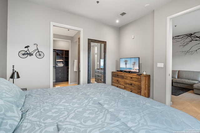 bedroom with a spacious closet, a closet, and light tile patterned floors