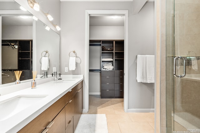 bathroom featuring double sink vanity, tile patterned flooring, and a shower with shower door