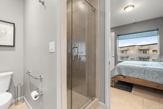 bathroom with toilet, tile patterned floors, and a shower with shower door