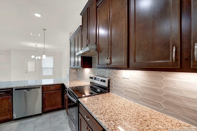 kitchen with appliances with stainless steel finishes, light stone countertops, decorative backsplash, and decorative light fixtures