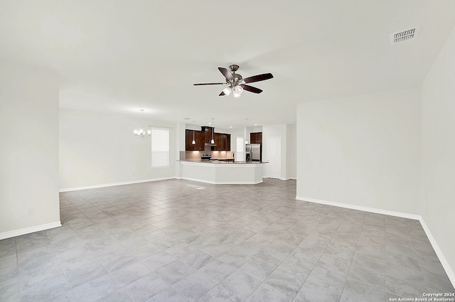 unfurnished living room with ceiling fan with notable chandelier and light tile patterned flooring