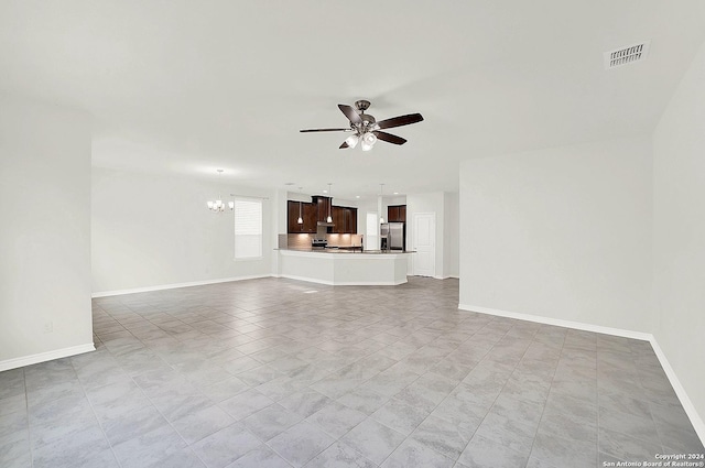 unfurnished living room featuring ceiling fan with notable chandelier