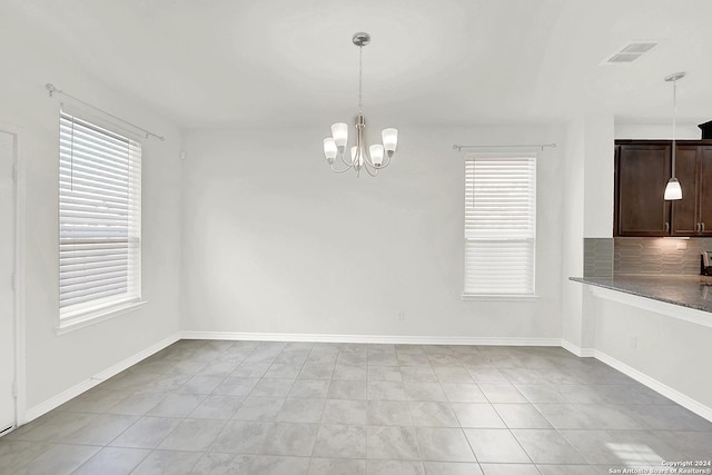 unfurnished dining area with a chandelier